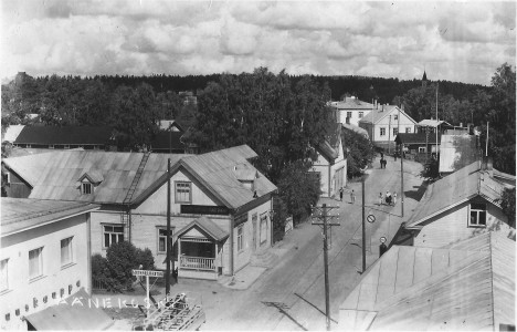 Tämä Yhdyspankin (1938) katolta V.Ehderin ottama kuvakortti Kauppakadun kapeimmilta kohdilta on 30-luvun lopulta. Siinä ei enää näy ojia. Etuoikealla on Itikka/Keskus Oy, Osuuskauppa Keskimaa Esso-mittareineen ja Lyytisen rakennukset ennen Salmelinin pajaa ja putkaa. Vasemmalla puolella tietä  Äänekosken osuuskaupan kivirakennuksen kolmaskin rakennusvaihe (1939) lienee ohi ja Puuran matkustajakodille menevän kujan toisella puolella on Paul Huttusen kauppa, jossa siis myös pankki. Seuraavana on Ahosen kauppa ja mutkassa koivun takana Ehderin tielletyöntyvä valokuvaamo.