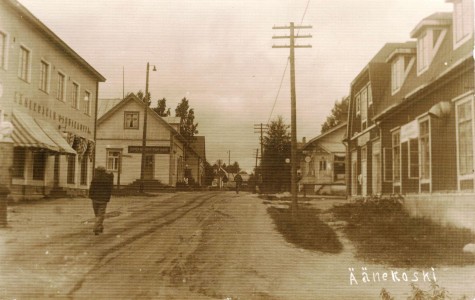 Lähempänä Viiskulmaa  ojat kävivät vähemmän tärkeiksi, kun mäki jyrkkeni. Huomaa katulamppu (1926) matkailijakotiin vievän  kujan alussa Osuuskaupan ja Huttusen (Maaseudun Osake-Pankki samassa) kaupan välissä. Vastapäätä Kauppakadun toisella puolelle Jyväskylän Osuuskaupan (1921) rakennus, jossa hauska kulmaovi. Kuva on Ritasen tai Ehderin ottama 30-luvun lopulla – postikorttipainatus ”Suomi – Finland”, mutta ei kulkenut. Varsin harvinainen.