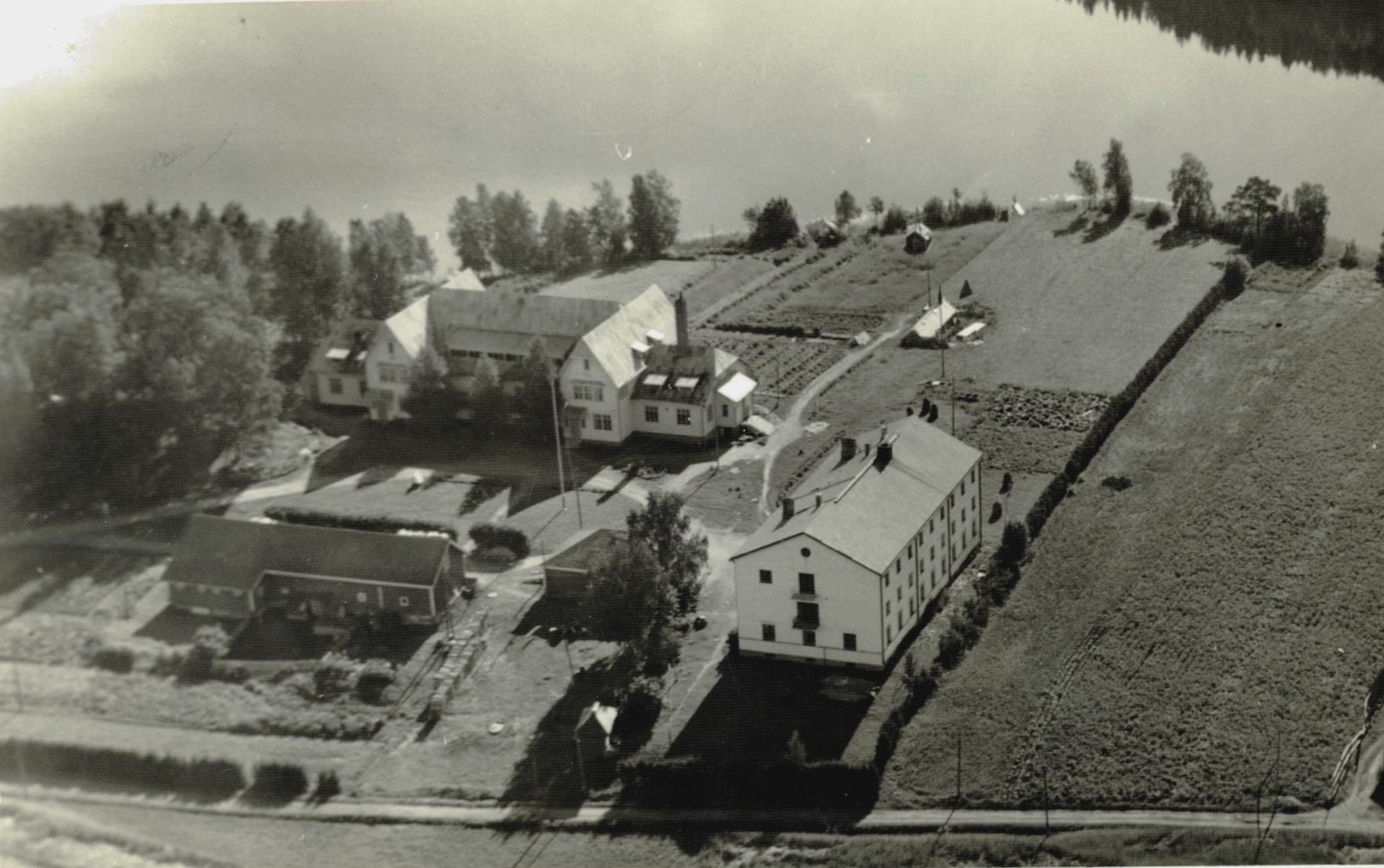 Tämä harvoin tavattava ilmakuva on Albin Aaltosen varhaistuotantoa vuodelta 1953. Etualan kivitalo oli pääasiassa poikien asuntolana. Takana näkyvät kasvitarhat ja pumppuhuone lähellä rantaa. Etualalla on kuusiaita jo istutettu ja ulkorakennus täydessä käytössä. Siinä vasemmalla on liiteri, sitten tyttöjen ulkohuonetilat, kalustovaja ja talli ja myös autotalli. Myöhemmin rakennusta lyhennettiin purkamalla liiteri.