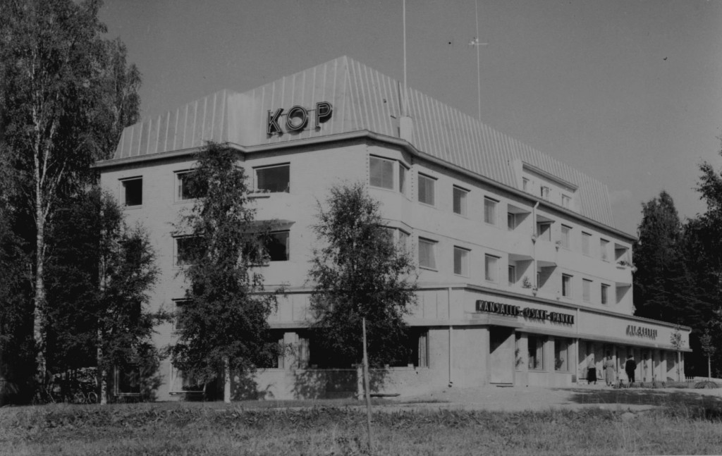 Tämä KOP-talona aiemmin tunnetun kerrostalon erikoisuus on, että maanmuotoa hyväksikäyttämällä se nousee toiselta sivultaan nelikerroksiseksi.  Suunnittelijana on ollut jyväskyläläinen arkkitehti toimisto Jorma Paatola.  Pankkikeskittymä Asemakadun täällä päässä on jatkunut Suolahden alusta asti. Vuonna 1958 valmistunutta kerrostaloa edelsi jo Keiteleentielle 1949 noussut Säästöpankin kivikerrostalo.  
