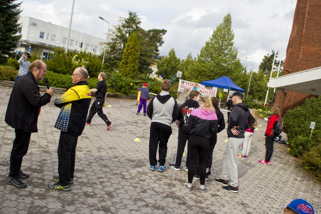 Kaupungintalon edessä sijainnut softtennis oli päivän suosituin rasti. Pekka Häyhä (vas.) juonsi koko tapahtuman keskustelemalla rastien päälliköiden kanssa.  