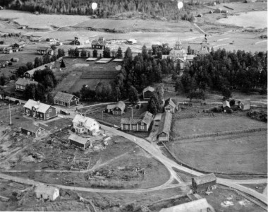 Vanhin Karhumäen ilmakuvakortti Konginkankaasta on kotva suuren tulipalon 1931 jälkeen, 27.7.1934, napattu kuva kylän keskustasta. Se on jo sen verran harvinainen, että Ramikin joutui lainaamaan Helena Pasasen kokoelmissa olevaa korttia. Lähes suoraan samalta kohdalta maan päältä on otettu samoilta ajoilta korttikuva, joka on esitelty Ramin kortit 16:ssa. Ilmakuvassa näkyy uudelleen rakennetun Osuuskaupan myymälän edessä hieno auto. Tulevan kansakoulun (1936) paikkeilla jo jotakin suunnitellaan – mitähän nuo neljä kasaa ovat, hirsiäkö?